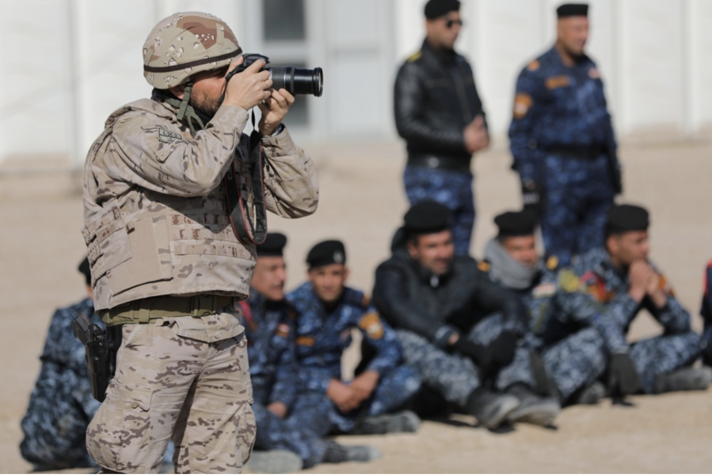 A CJTF-OIR trainers takes an image of Iraqi Police Force training to build greater security in liberated areas